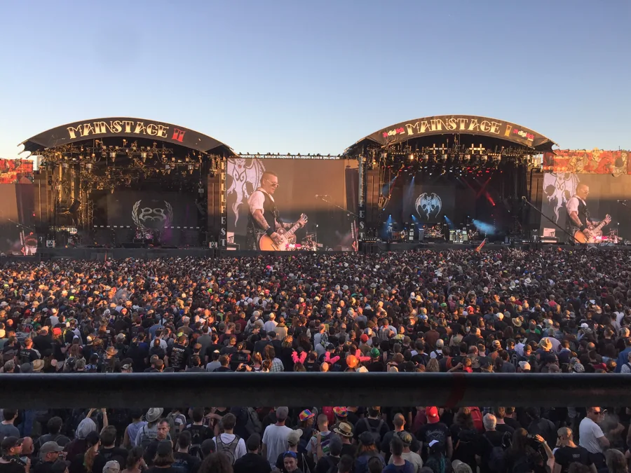 Wide view of an outdoor festival crowd facing two stages